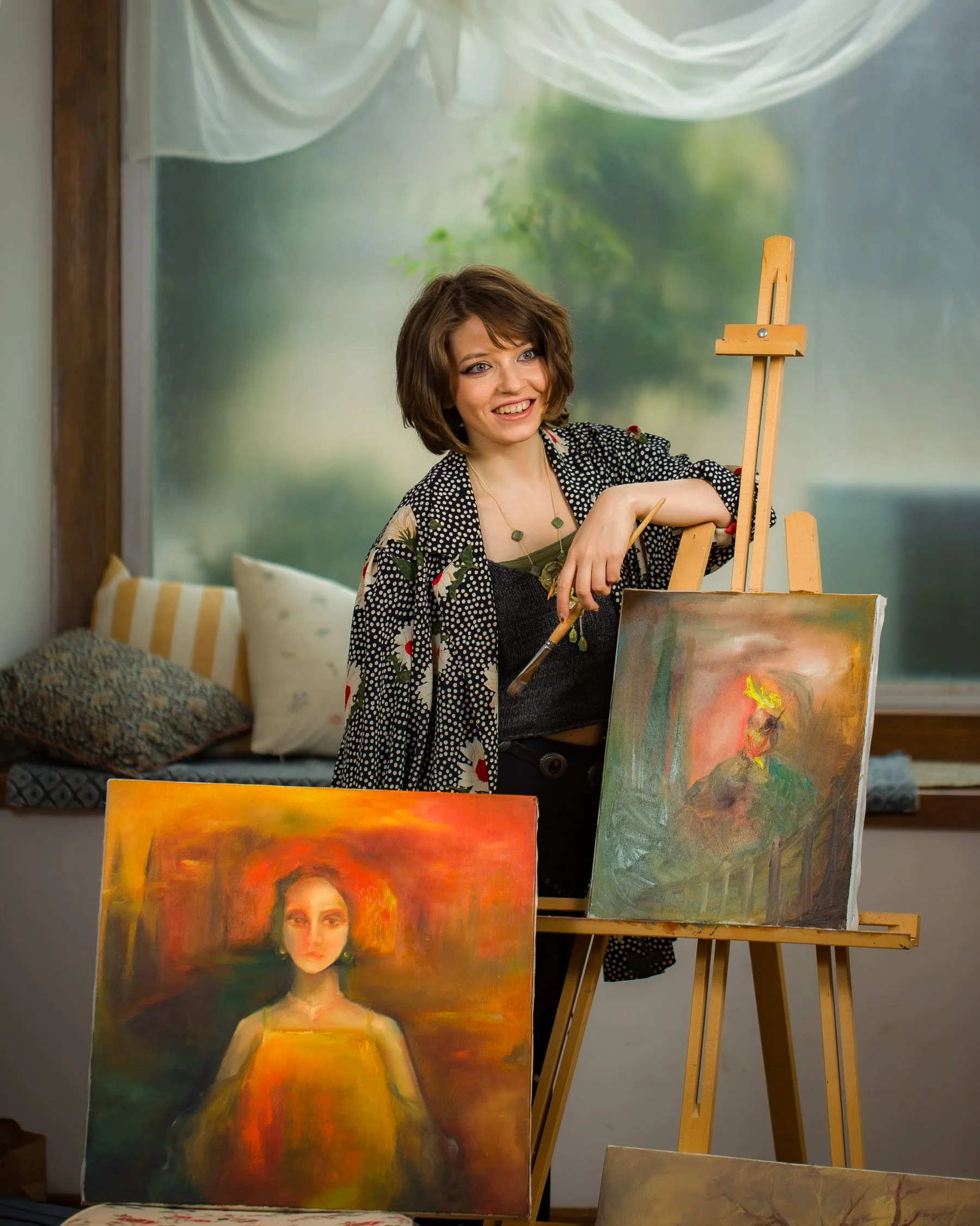 Painter standing beside her canvases in the studio