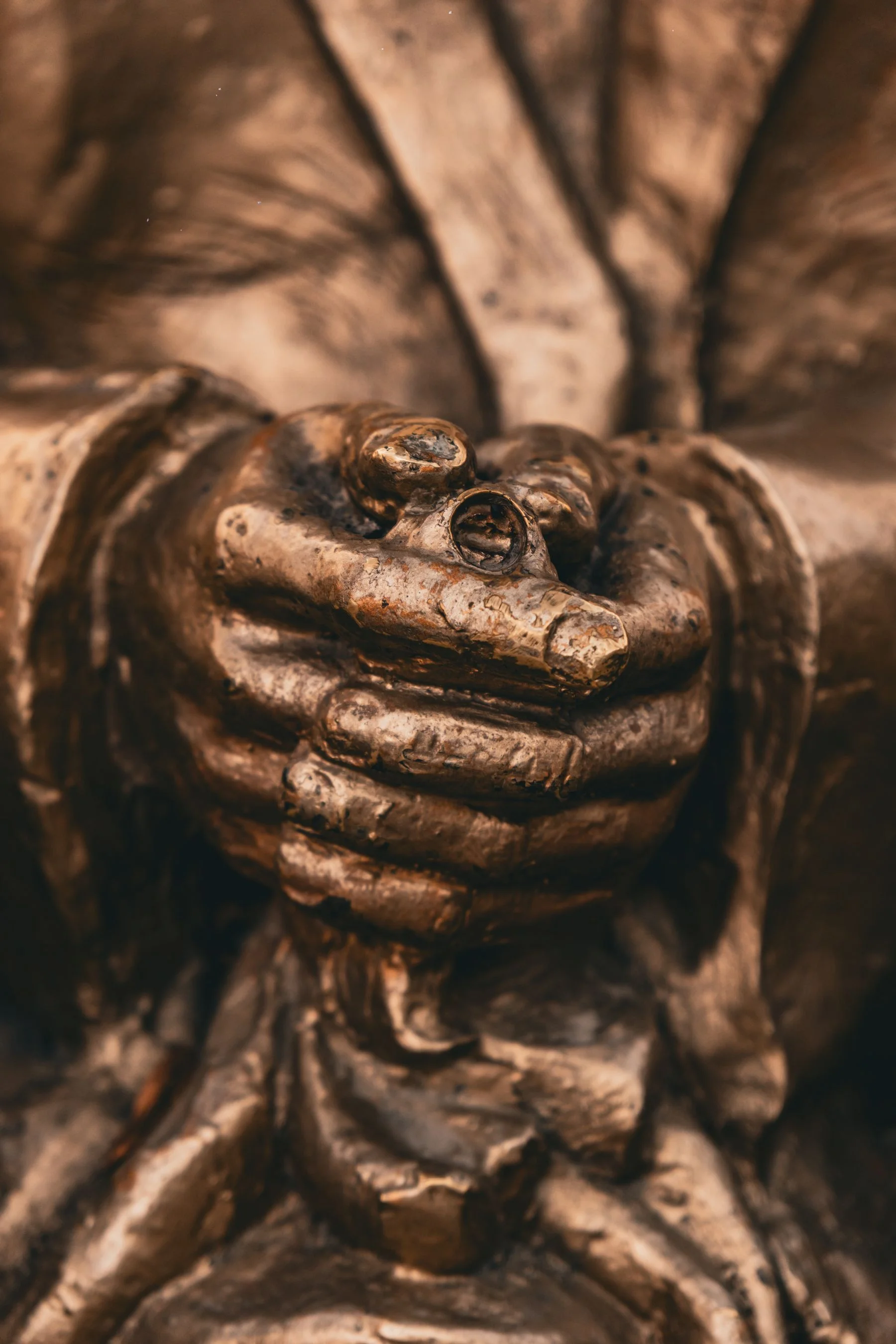 Bronze hands holding a ring