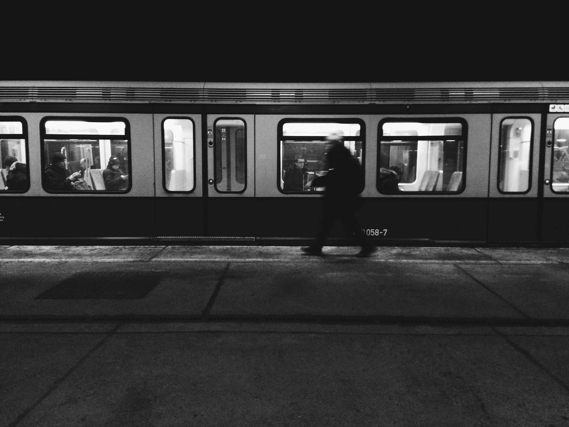 Travellers waiting on a station platform at night
