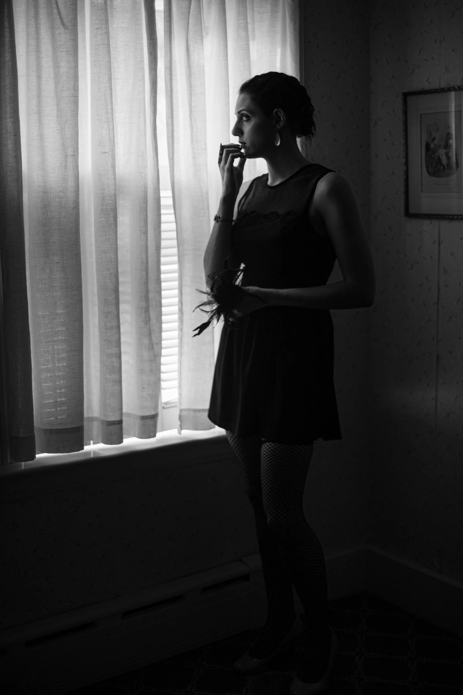 Woman standing by a window, lost in thought