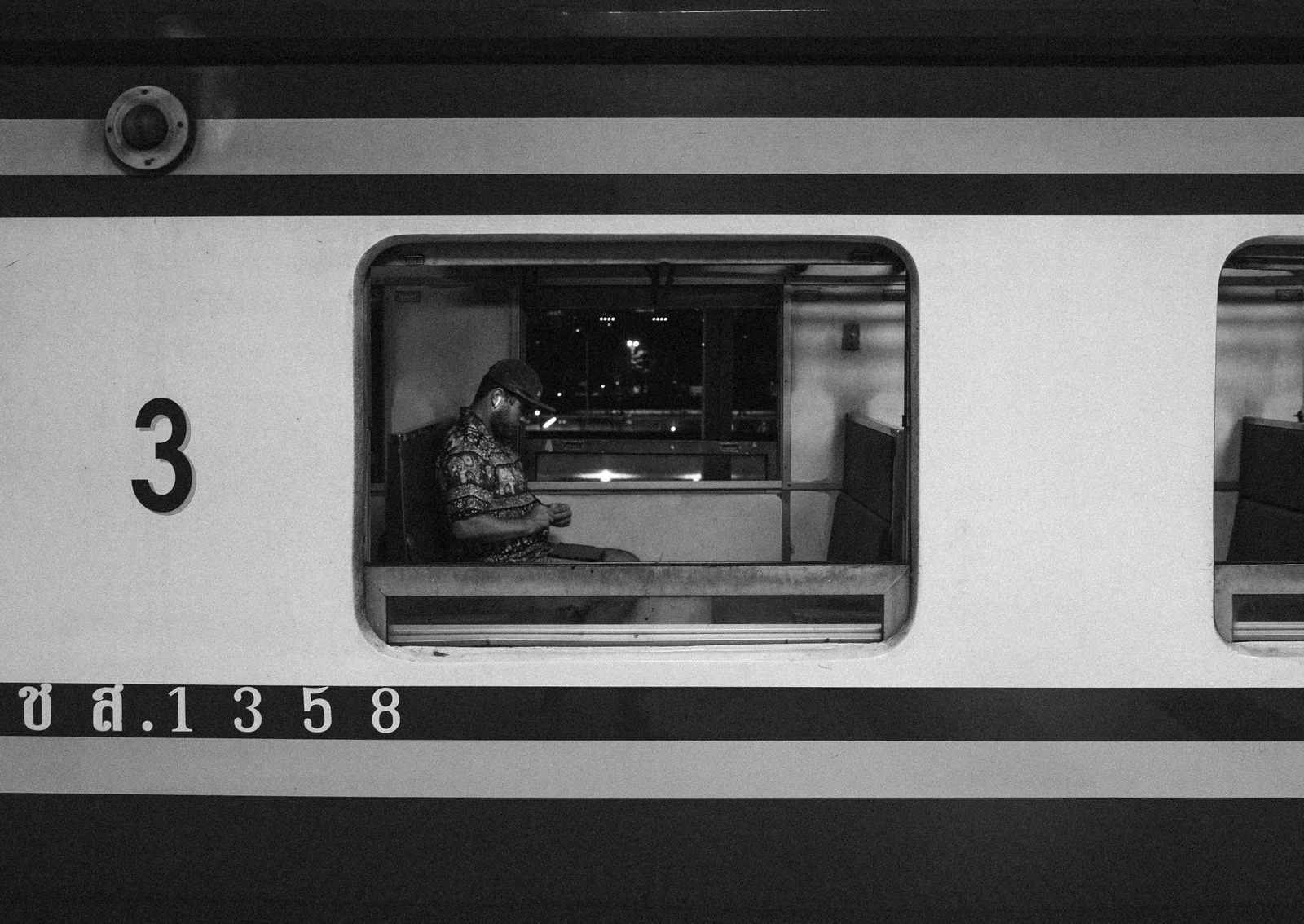 A man alone in a train carriage at night