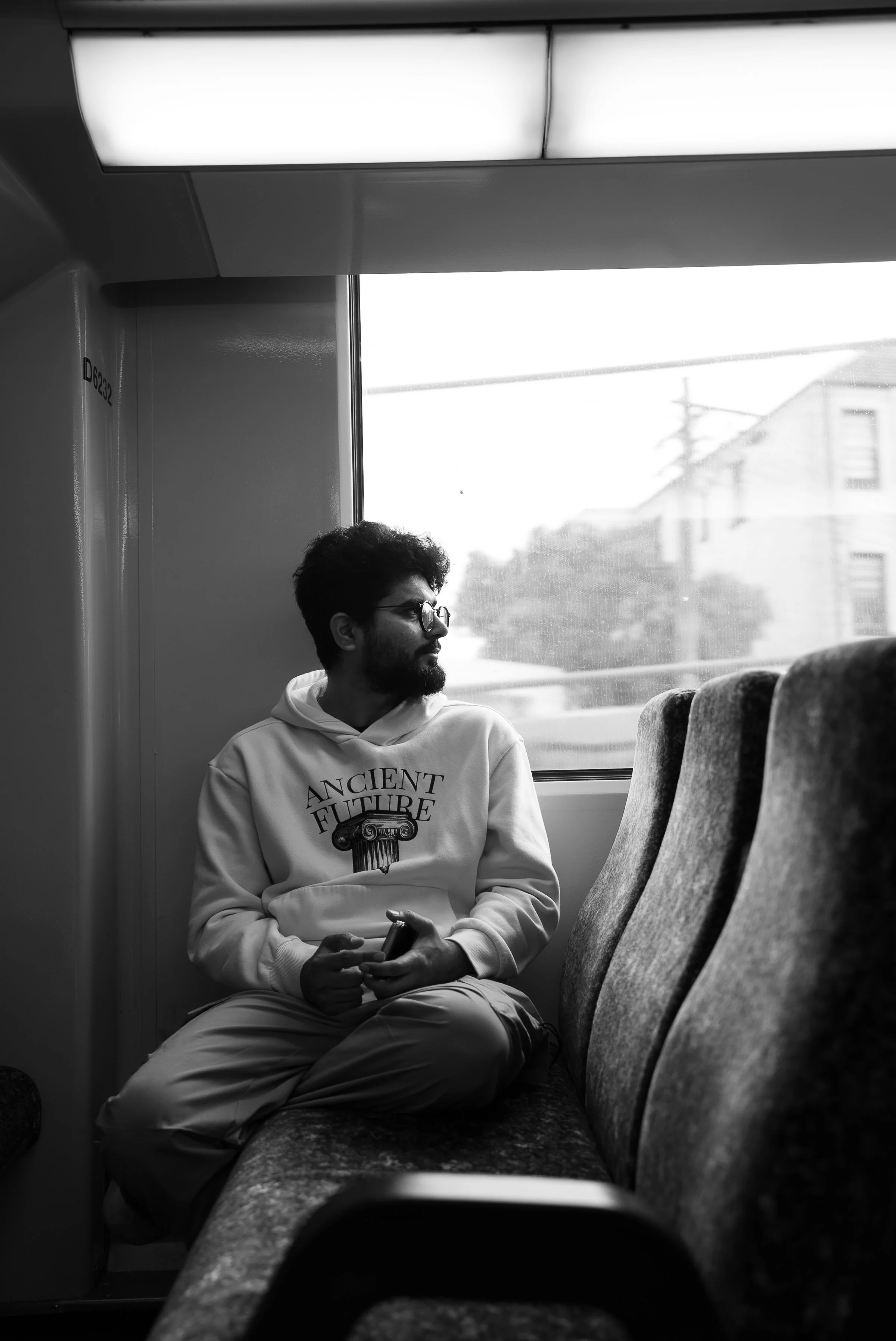A man in a train seat looking out of the window