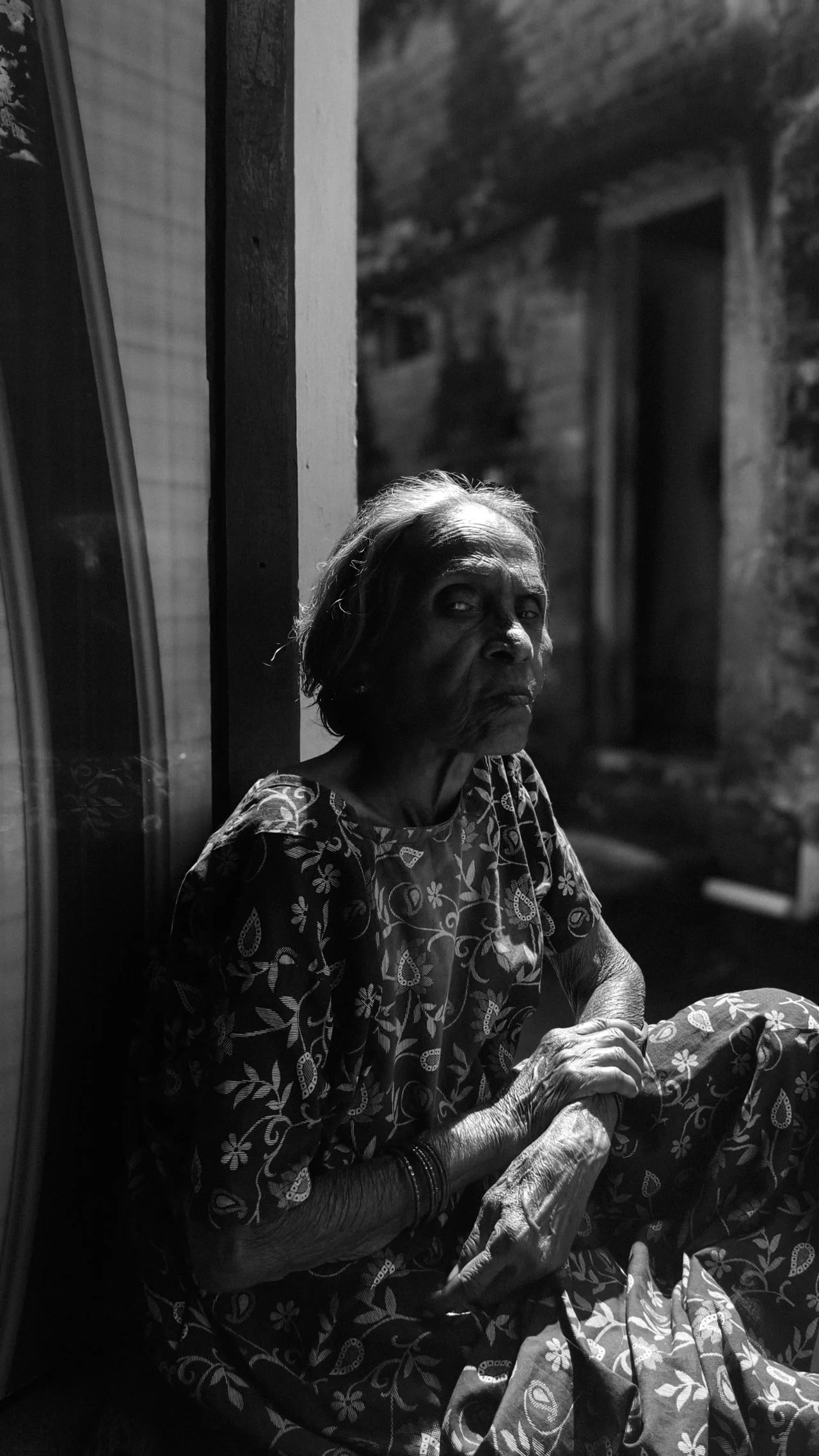 Elderly woman in sunlight with deep shadows