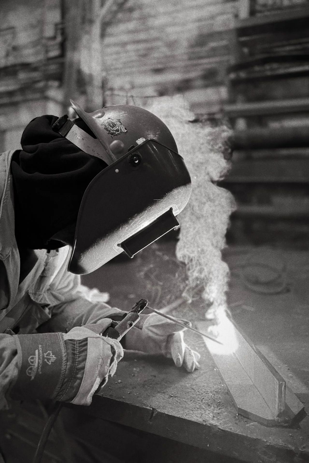 Welder surrounded by sparks in a shipyard