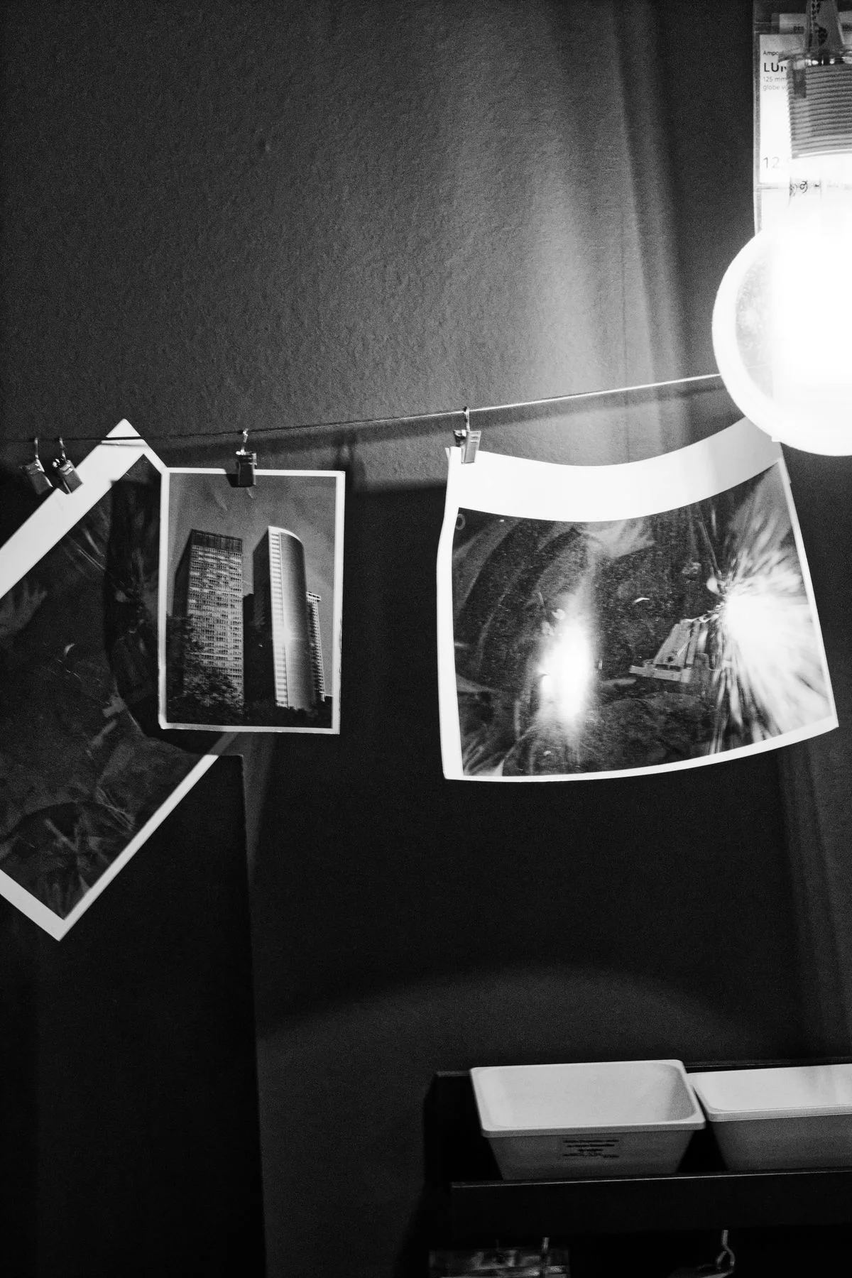 Finished black-and-white silver gelatin prints drying on a line in the darkroom
