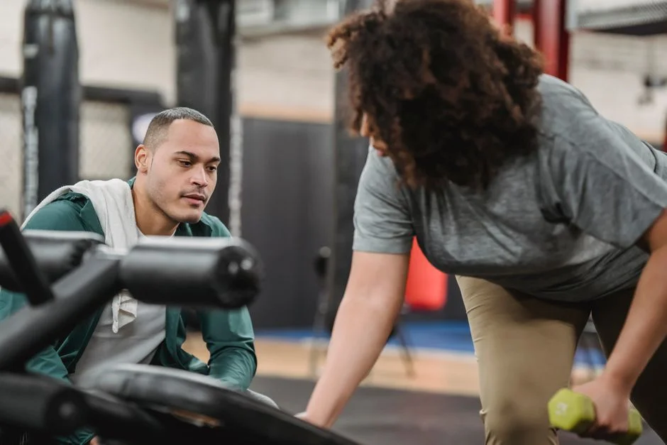 A coach guiding a member through a personal training session