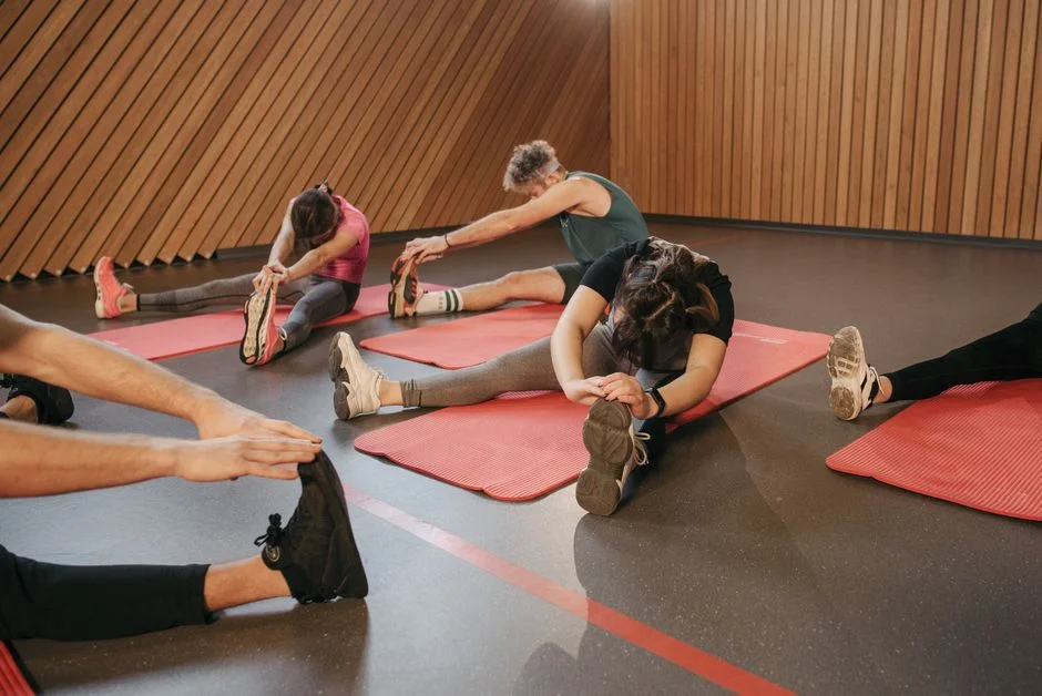Members stretching on mats during a Mobility class