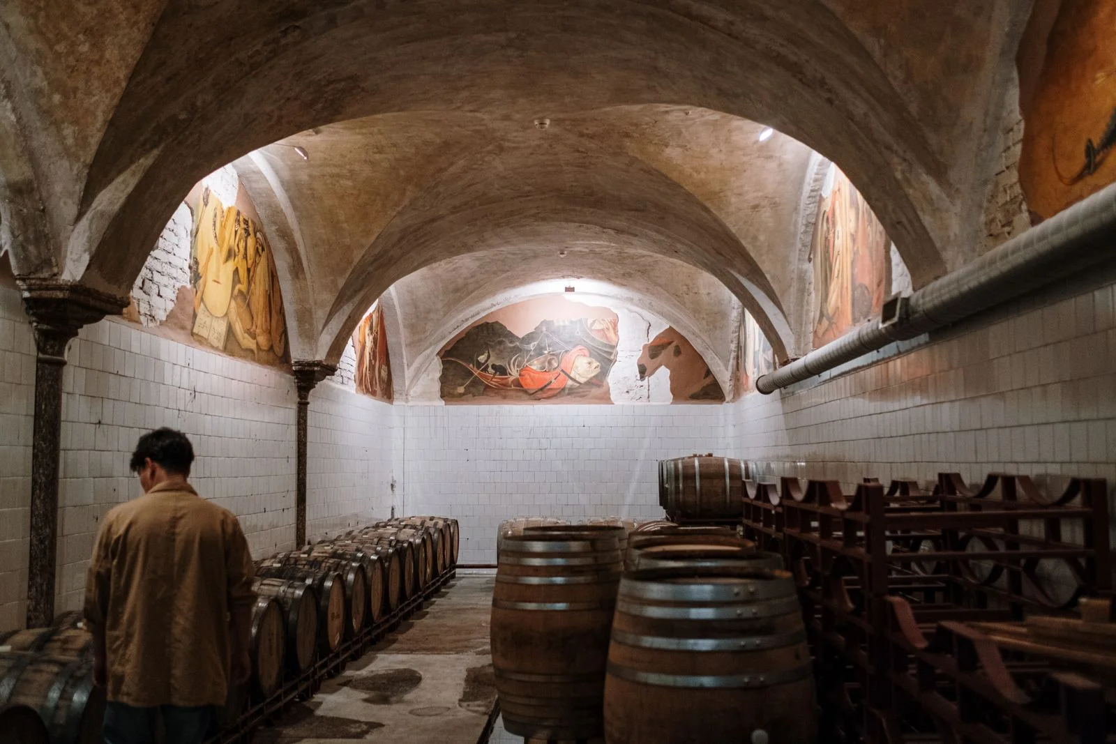 Barrels resting under the vaulted arches of a grower's cellar