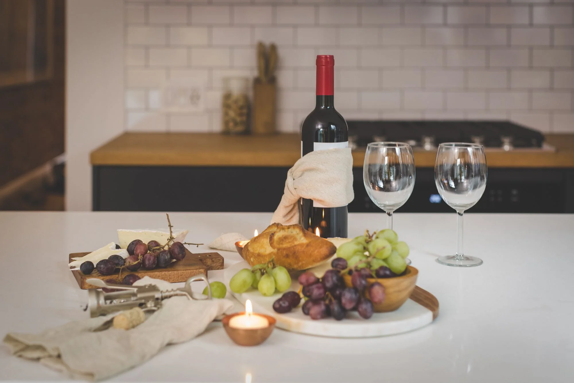 Red wine, cheese, grapes and bread by candlelight