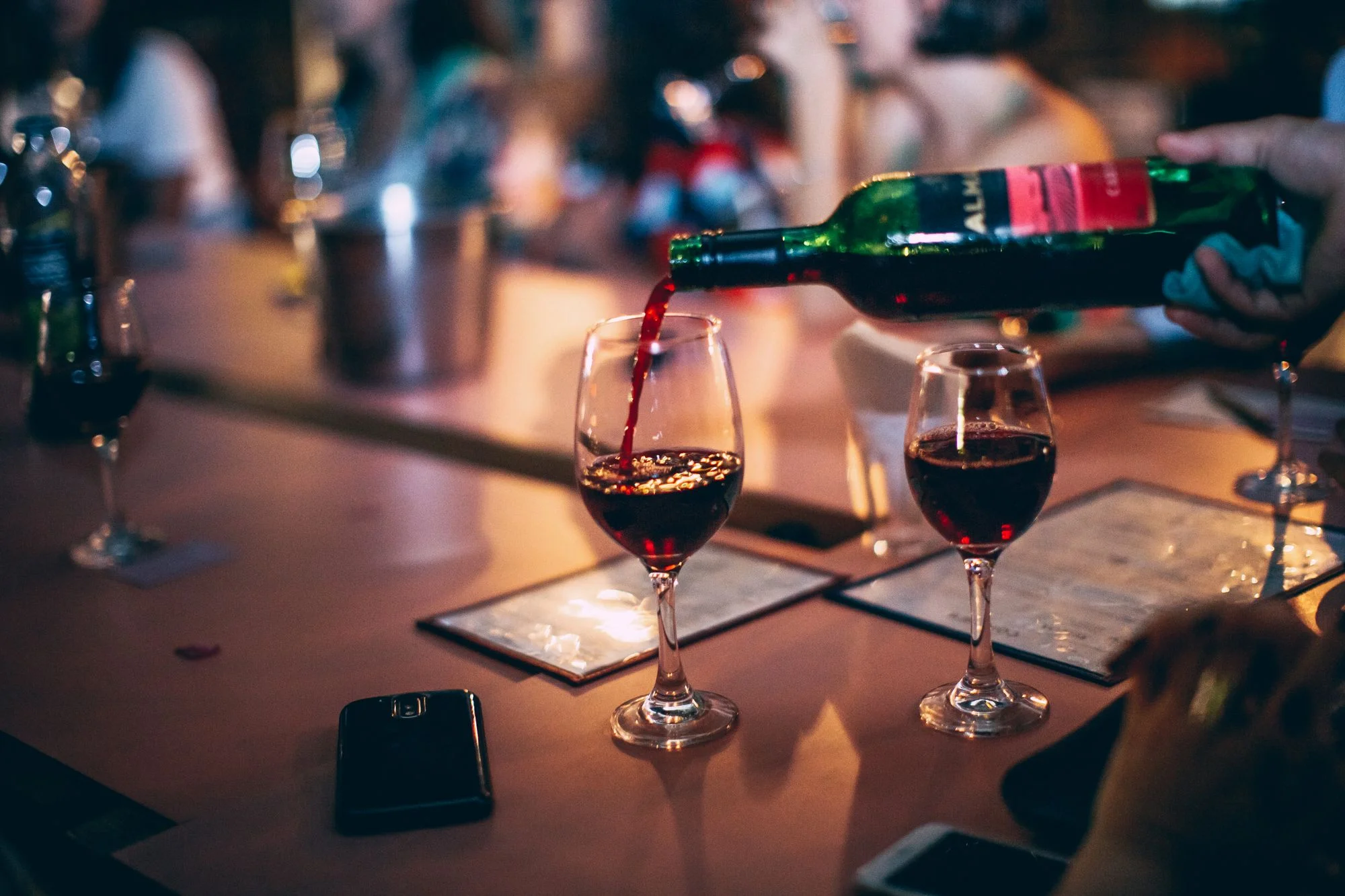 Red wine being poured at the bar