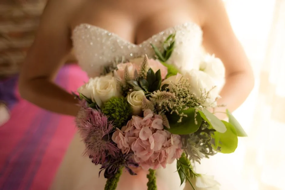 A bride holding a garden-style wedding bouquet
