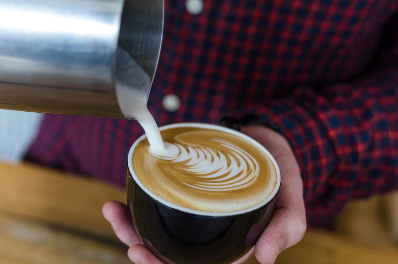 Latte versato che disegna una rosetta in una tazza